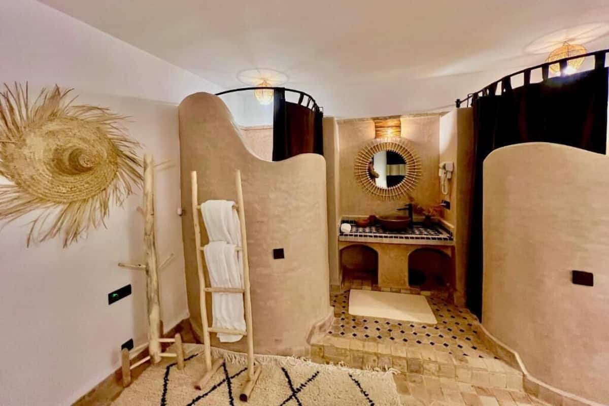 Un baño con un espejo grande, un perchero para toallas y un suelo con diseño.