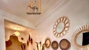 Ένα υπνοδωμάτιο με ένα κρεβάτι, ένα κομοδίνο, έναν καθρέφτη και διακοσμητικά έργα τέχνης στον τοίχο.