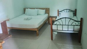 A small, clean room with two beds, a wooden desk, and a tiled floor. - Evot Wave (Himmafushi)