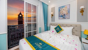 Een hotelkamer met een bed, een schilderij, een lamp en uitzicht op een klokkentoren.