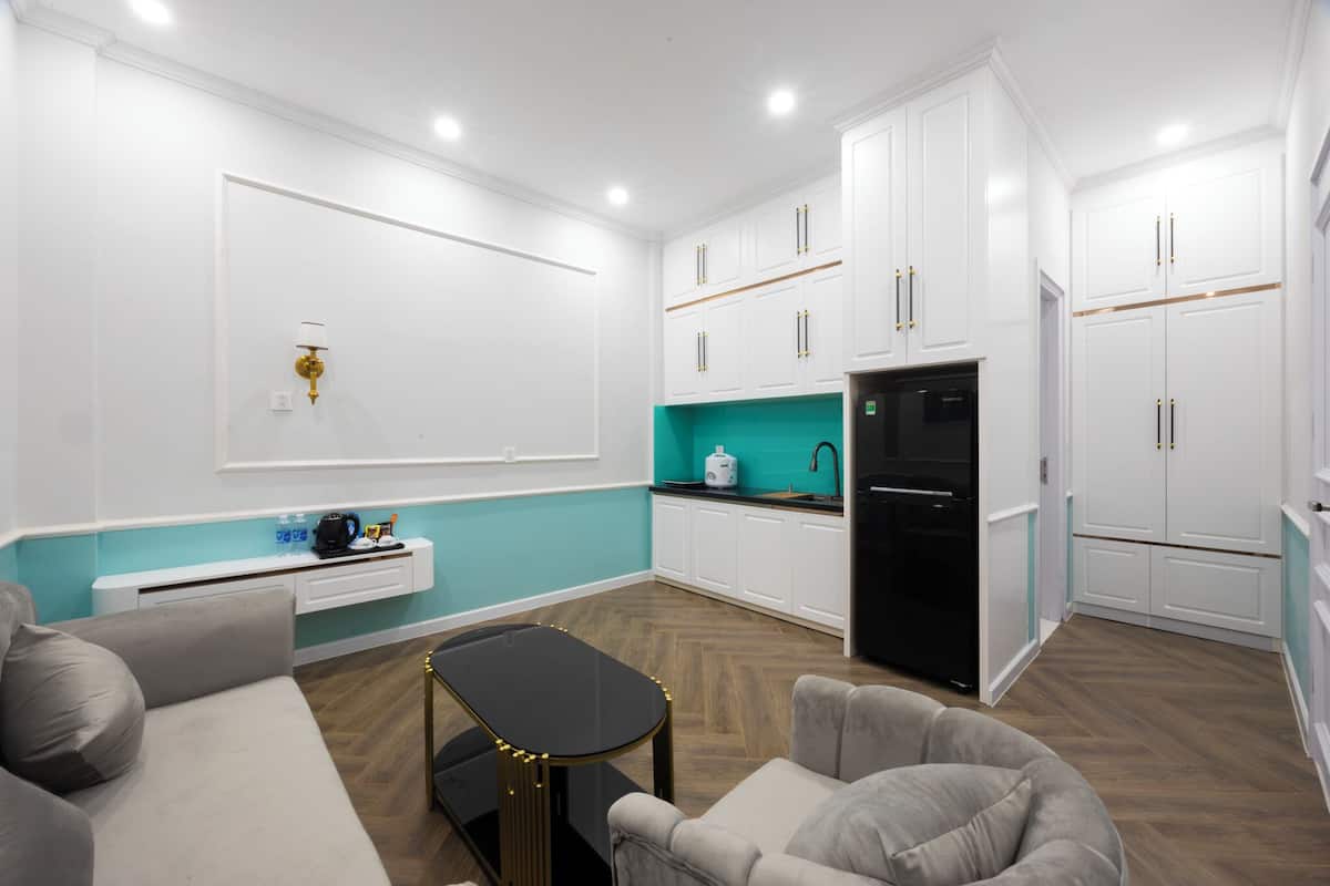 A compact living space with a kitchenette, a sofa, a coffee table, and a dining table.