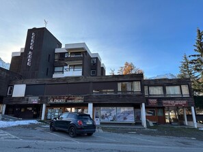 A building with a sign for 'Caisse Point Show' and 'Alpages Immobilier' on the ground floor. - 50m from shops, 3rd floor, balcony, fireplace or stove, ski locker, 40m², Vars (Vars)
