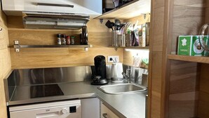 A compact kitchen with a dishwasher, a coffee maker, and a microwave. - 50m from ski slopes, 3rd floor, balcony, fireplace or stove, ski locker, 40m², Vars (Vars)