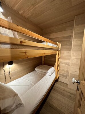 A bunk bed room with wooden walls and a door. - 50m from shops, 3rd floor, balcony, fireplace or stove, ski locker, 40m², Vars (Vars)