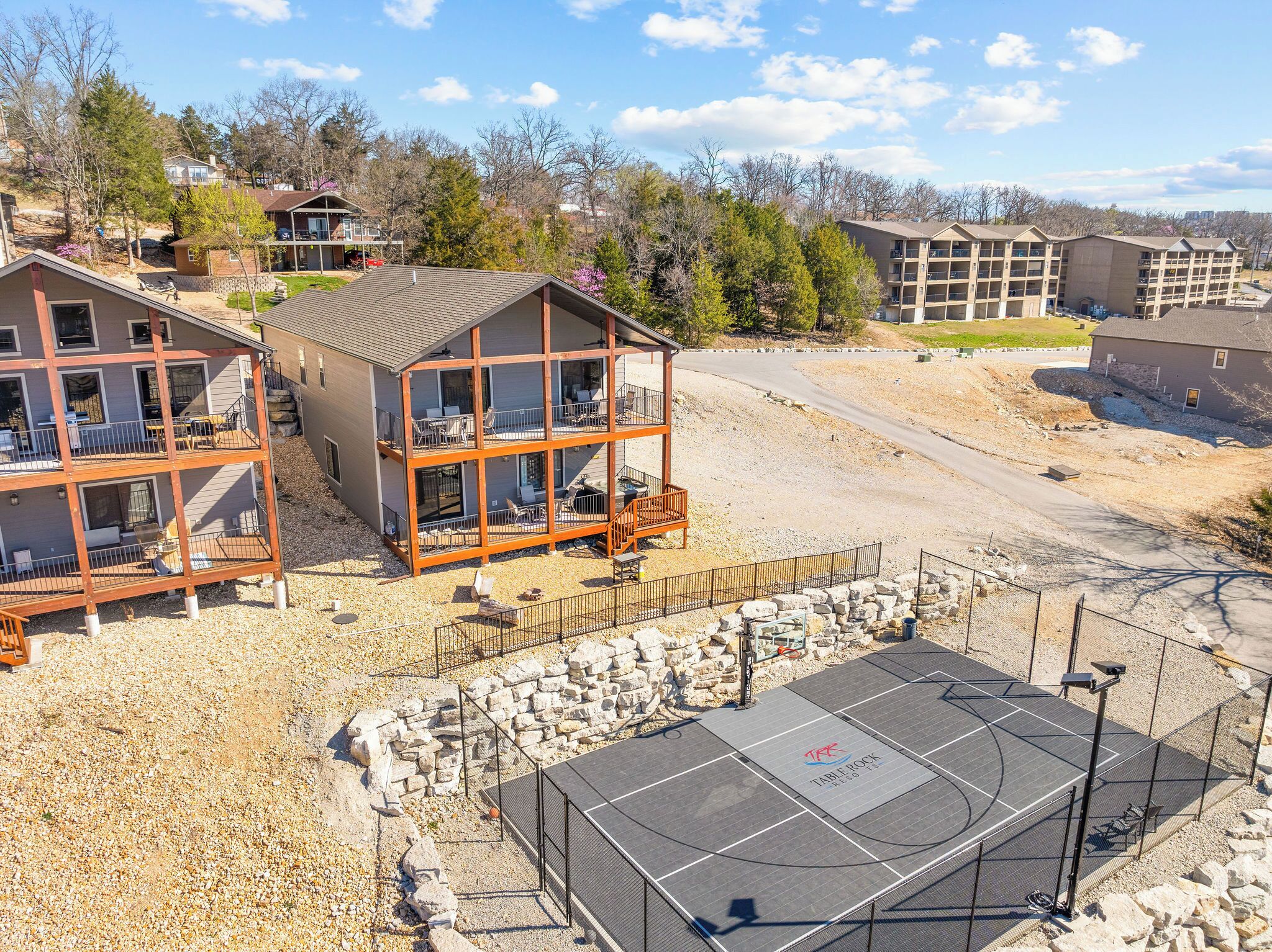 A multi-story building with balconies, a gravel driveway, and a solar-powered outdoor area.