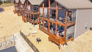 Une rangée de chalets en bois dotés de balcons, une allée de gravier et un ciel dégagé.