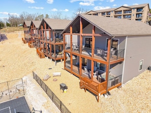 Une rangée de chalets en bois dotés de balcons, une allée de gravier et un ciel dégagé.