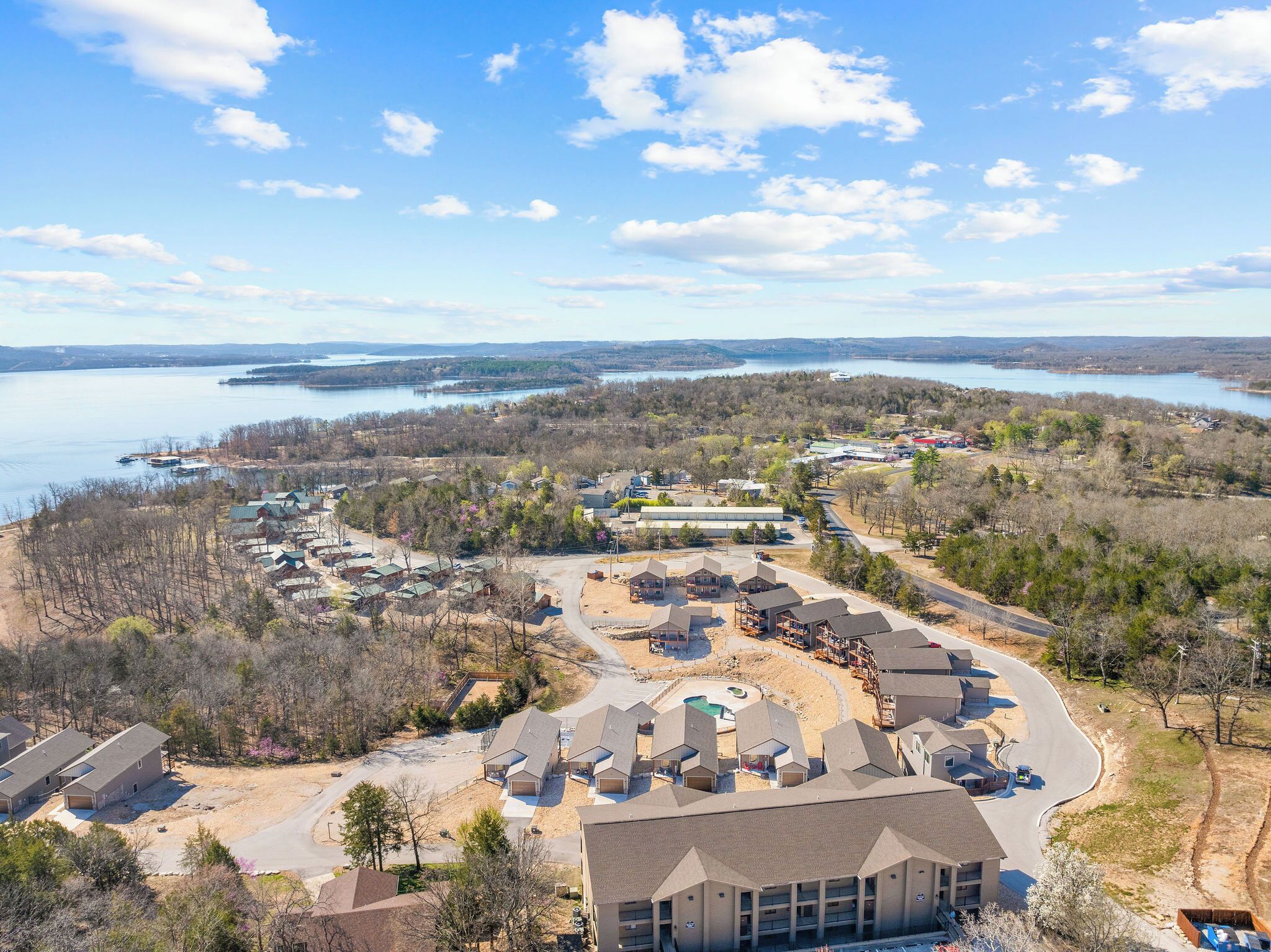 Un quartier résidentiel avec des maisons, un grand immeuble et un lac en arrière-plan.