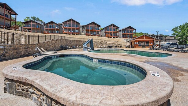 Un complexe hôtelier comprenant plusieurs bâtiments, un jacuzzi et une piscine.