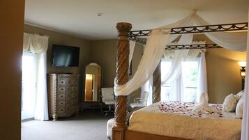 A four-poster bed with a canopy, a dresser, a television mounted on the wall, and a chair.