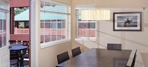 Una sala de conferencias con una gran mesa, cuatro sillas y una lámpara colgante.