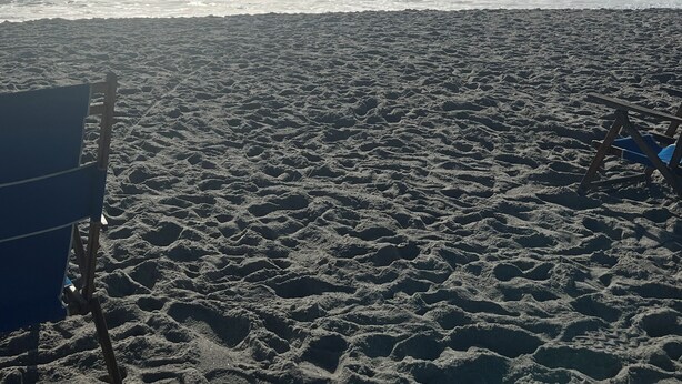 A beach with a large blue canopy structure.