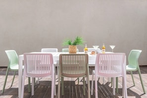 A table set with chairs, a woven basket, and bottles. - Chic Coastal Escape Near the Beach by SeaNRent (Nahariya)