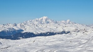 Une chaîne de montagnes enneigée, aux pics escarpés, sous un ciel dégagé.