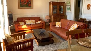 A living room with two leather sofas, a glass coffee table, and a wooden cabinet. - Apt. Biarritz Rés Carlton, Grande plage (Biarritz)