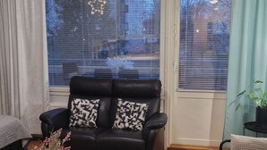 A living room with a black leather sofa, a wooden coffee table, and a grey rug. - Lakeside Serenity in Lutakko | sauna, parking, A/C (Jyväskylä)
