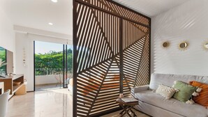 Una sala moderna con un sofá modular, una mesa de centro y un separador decorativo.