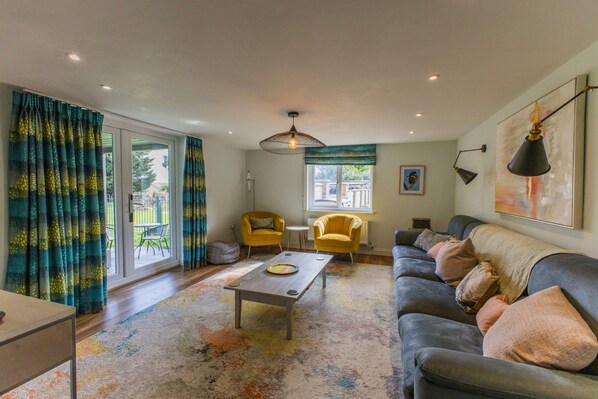 A living room with a sofa, a yellow armchair, a coffee table, and a floor lamp.