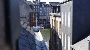 En smal kanal med byggnader på båda sidor, en båt förtöjd i mitten och ett kyrktorn i bakgrunden.