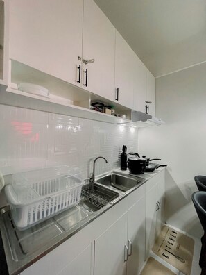 Een kookplaat, een waterkoker, kookgerei, borden en bestek