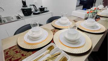Une cuisine moderne avec des armoires blanches, une cuisinière encastrée et un four à micro-ondes.