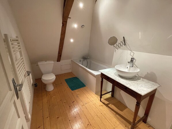 Une salle de bain comprenant des toilettes, une baignoire et un lavabo.