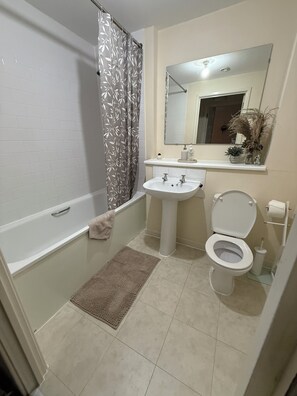 A bathroom with a bathtub, a sink, and a toilet.
