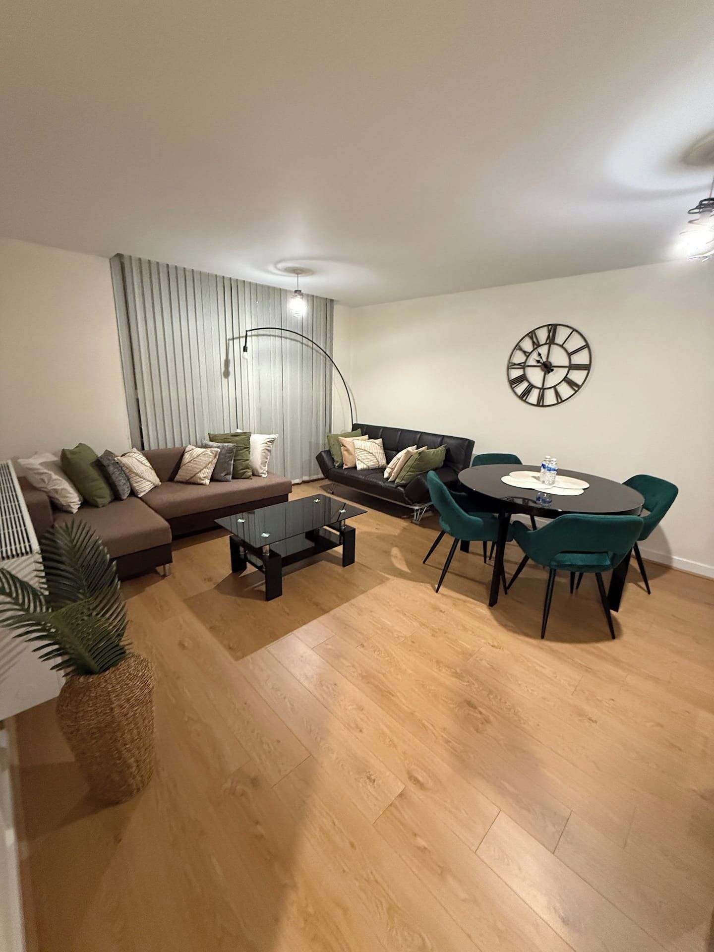 Ein Wohnzimmer mit einer Couch, einem Couchtisch und einem Esstisch mit Stühlen.