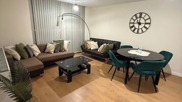 Ein Wohnzimmer mit einer Couch, einem Couchtisch und einem Esstisch mit Stühlen.
