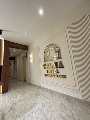 A hallway with a marble floor, a wall-mounted sign reading "CALMA HOTEL," and a decorative arch. - Calma Hotel (Cairo)