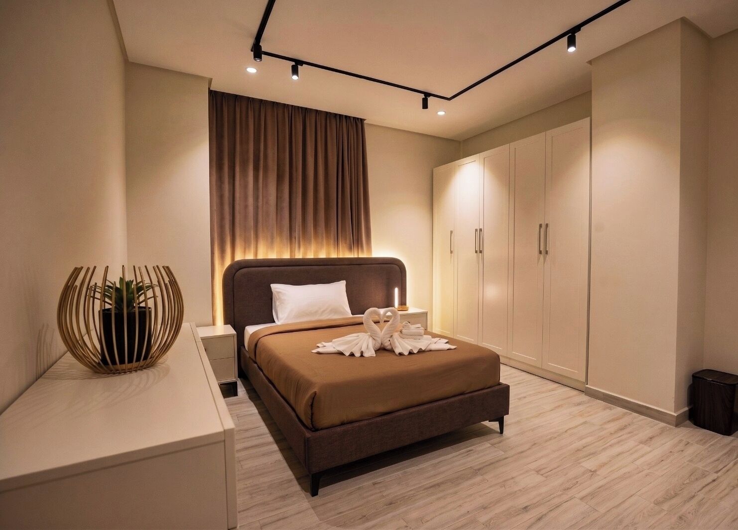 A modern bedroom with a bed, bedside table, and a wardrobe.