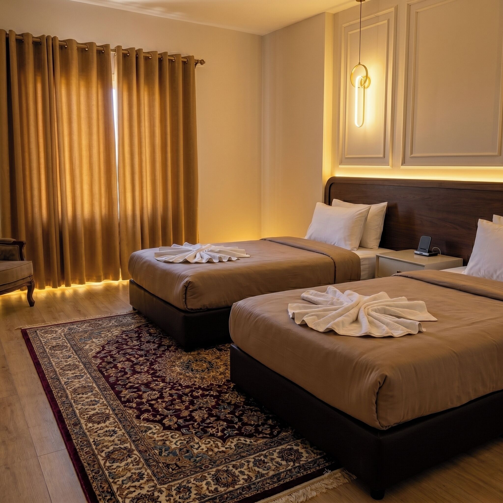 A hotel room with two beds, a large window with curtains, a wooden floor, and a patterned rug.