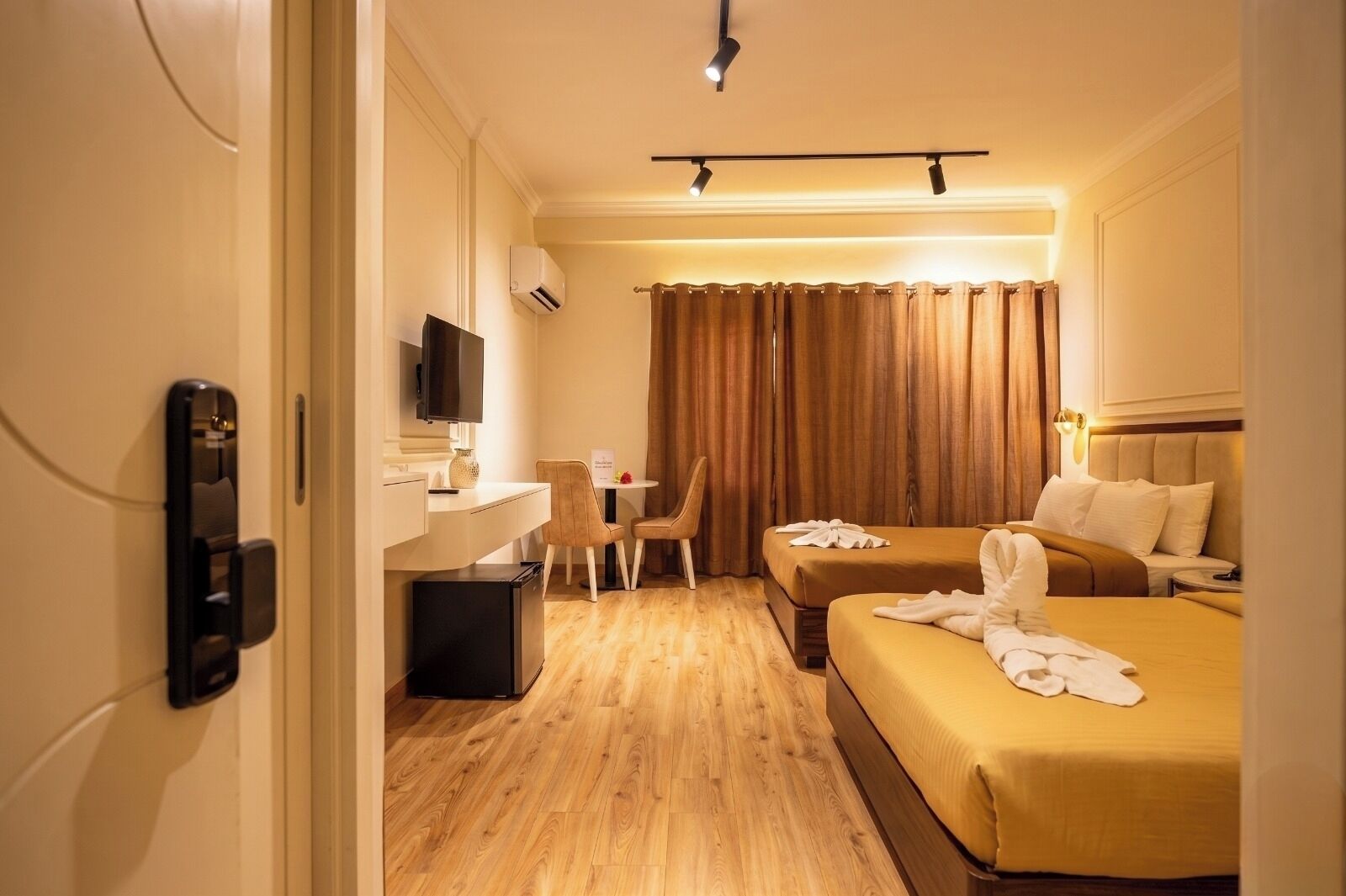 Ein Hotelzimmer mit einem Bett, einem Schreibtisch, einem Sessel, einem Fernseher und einer Minibar.