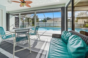 Ein heller Innenraum mit Pool, Sitzgelegenheit und großen Fenstern.