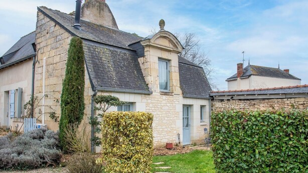 A stone house with a gabled roof, a chimney, and a small garden with various shrubs. - Le Petit Pavillon, located in the heart of the Anjou vineyards between Angers and Saumur (Tuffalun)