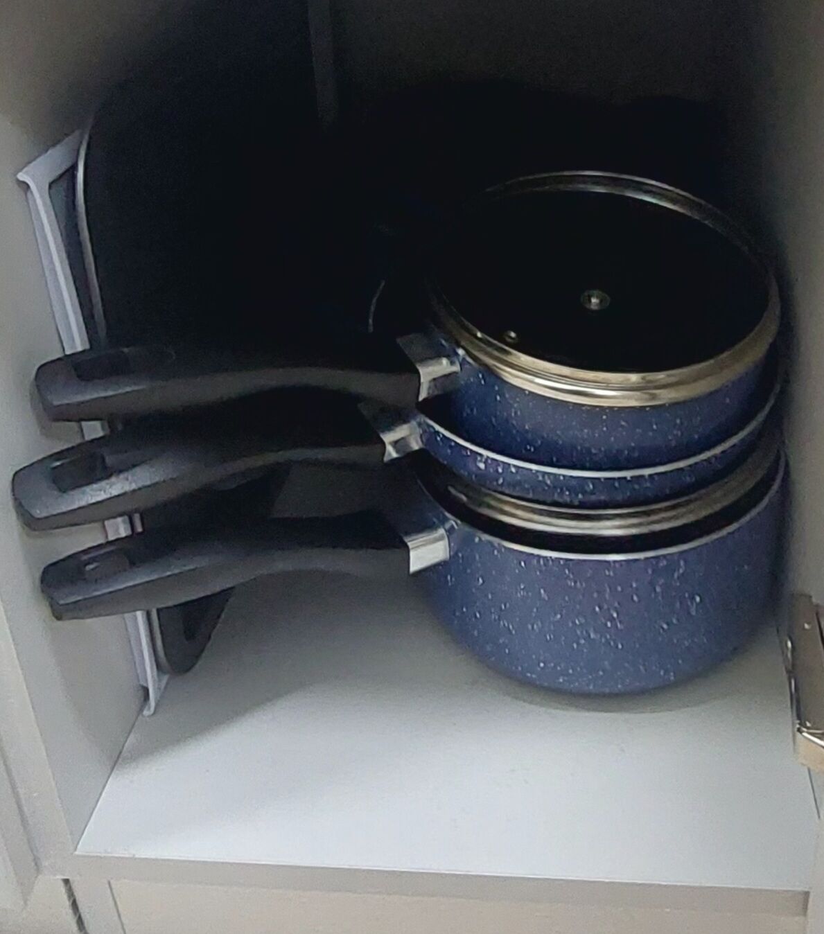 Una cucina con un fornello e una pentola blu sul bancone.