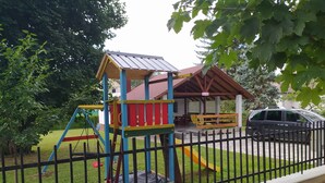A playground with a climbing structure, a slide, and a covered seating area. - Comfortable vacation home in a quiet area close to Lake Balaton (Szántód)