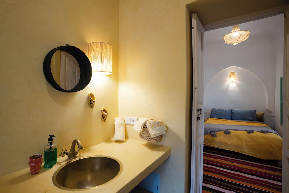 Une salle de bain équipée d’un lavabo, d’un miroir et d’un porte-serviettes.