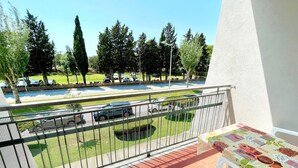 Un balcón con vista a un estacionamiento y árboles.