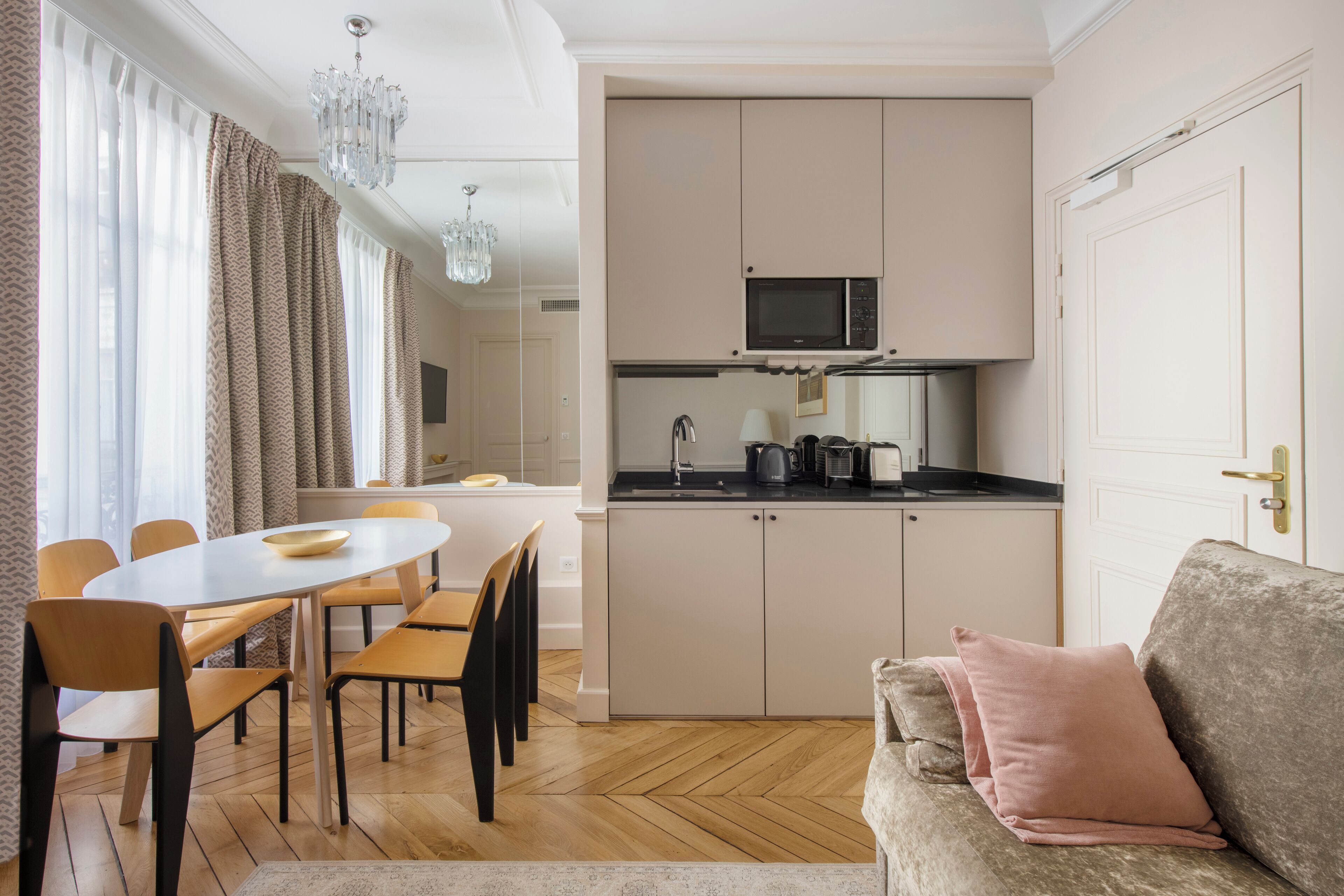 A compact living space with a dining area, kitchenette, and a sofa.