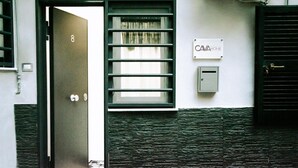 Une porte portant le numéro 8, une fenêtre avec des stores et une enseigne sur laquelle on peut lire « CAVA HOME ».