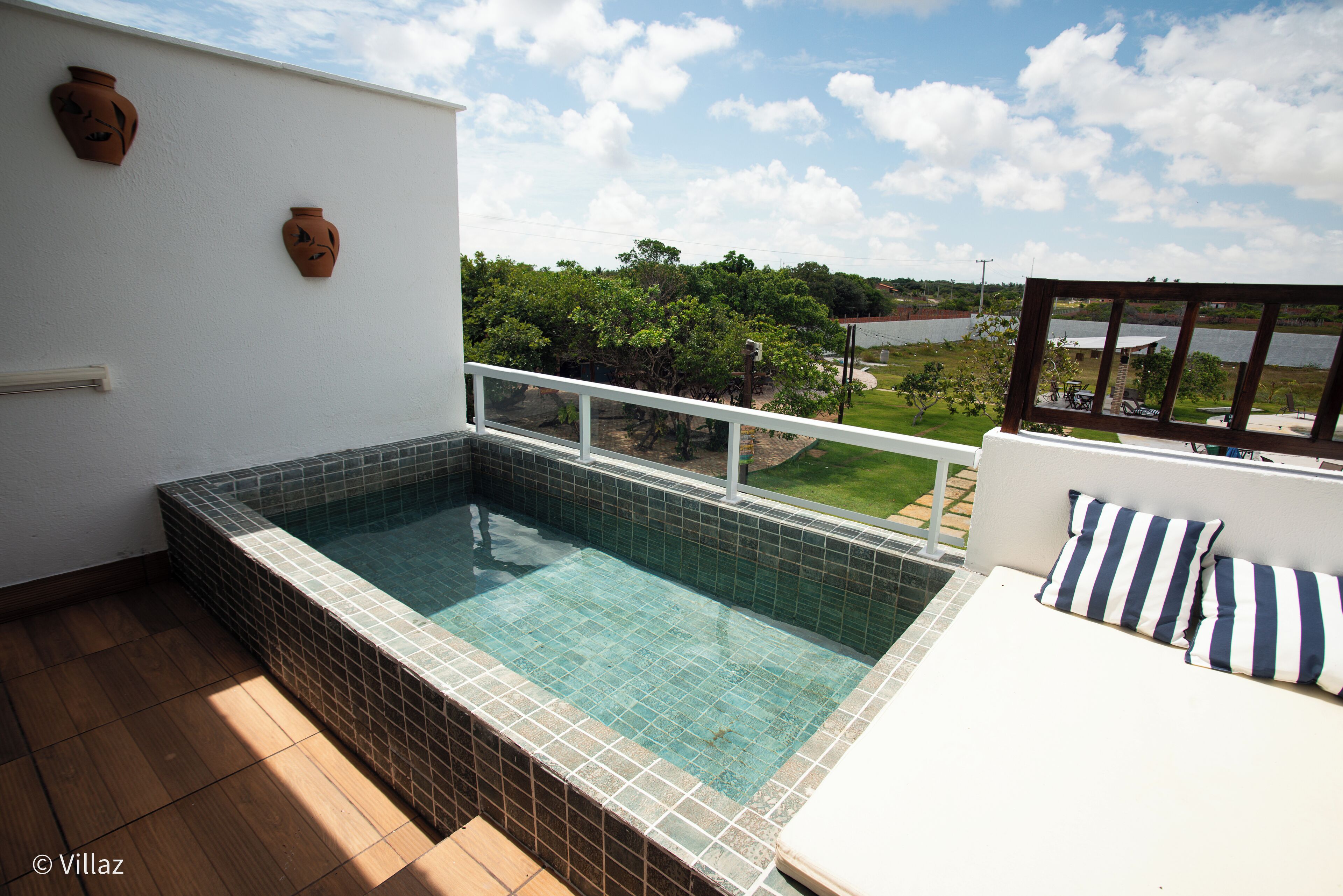 A rooftop pool with a view of a lake and trees.