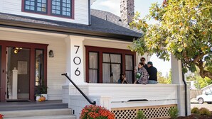 A two-story house with a front porch, numbered 706, and a chimney. - The Compass McMinnville (McMinnville)