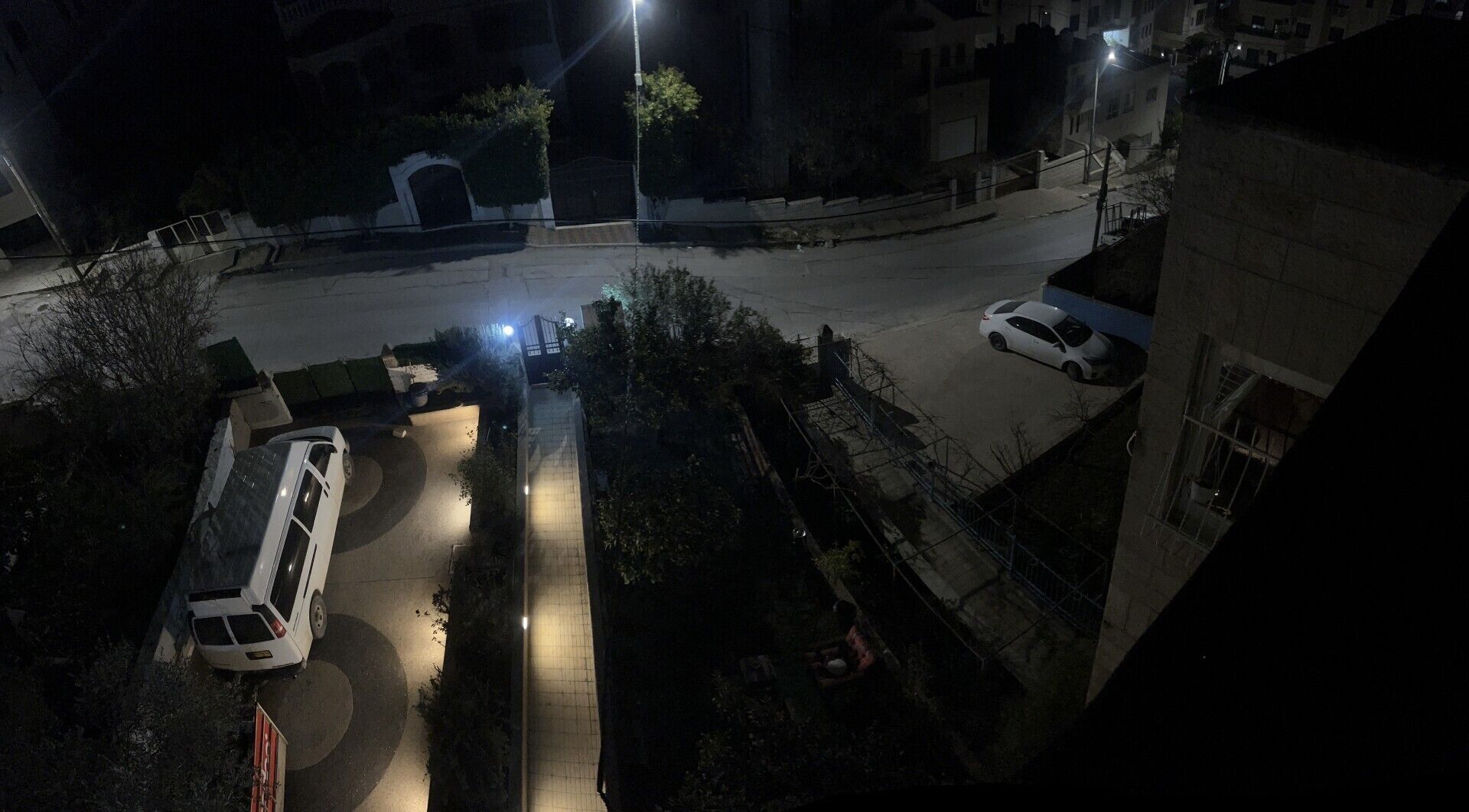 An aerial view of a parking area with cars and a building.