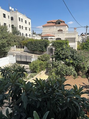 A residential area with a gated entrance, lush greenery, and buildings with traditional architecture.