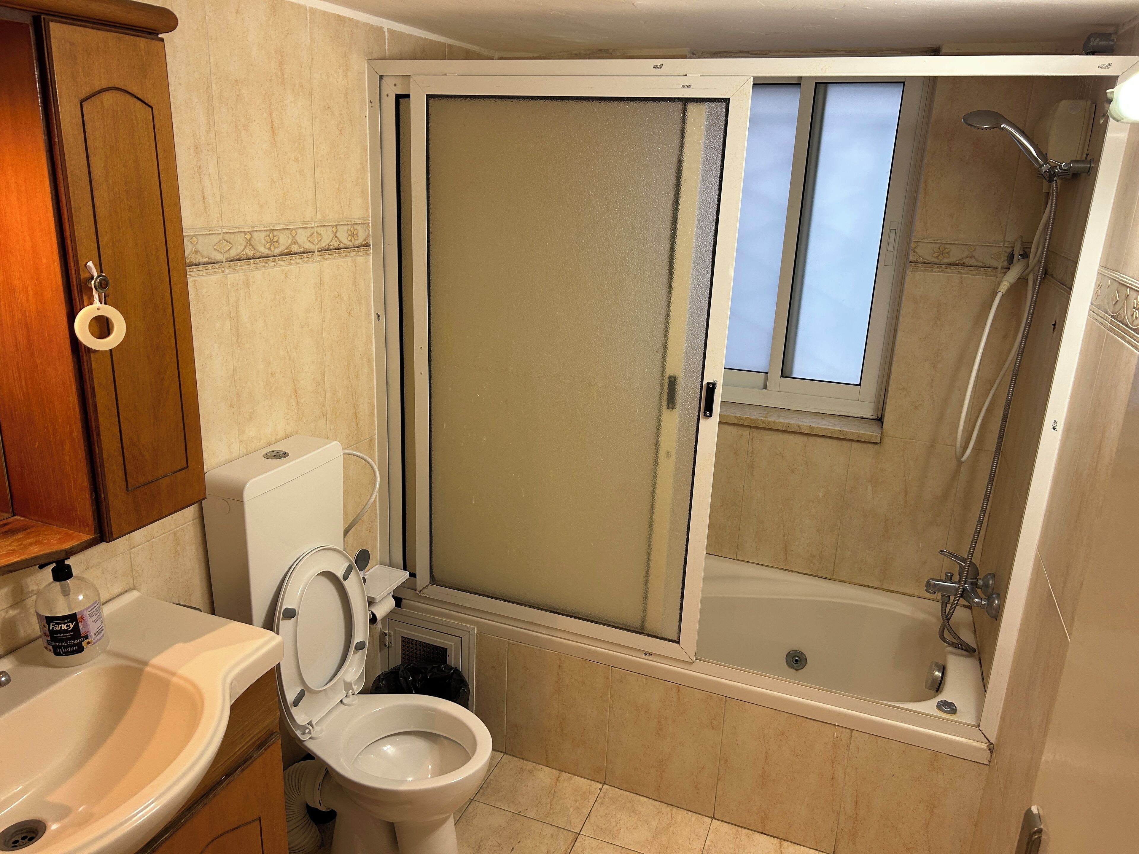 A bathroom with a toilet, sink, and shower.