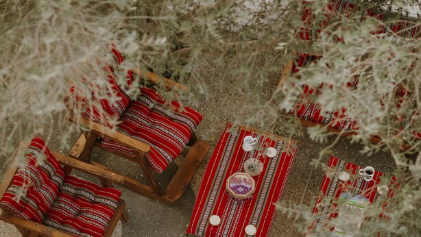 A room with wooden furniture and red patterned bedding. - OliveTreeHostel (Ramallah)