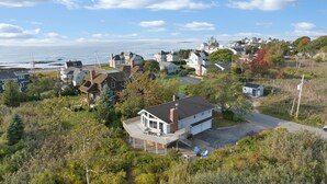 A coastal residential area with houses, a dock, and a view of the sea. - Walk to Kennebunk beaches! 4BR home with marsh views, large deck, and firepit (Kennebunk)