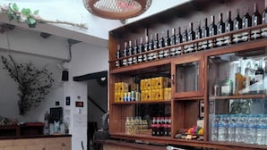 A bar area with a variety of bottles and a basket of lemons on a table. - One and a half blocks from the main square! Nice and cozy hotel. (Villa de Leyva)