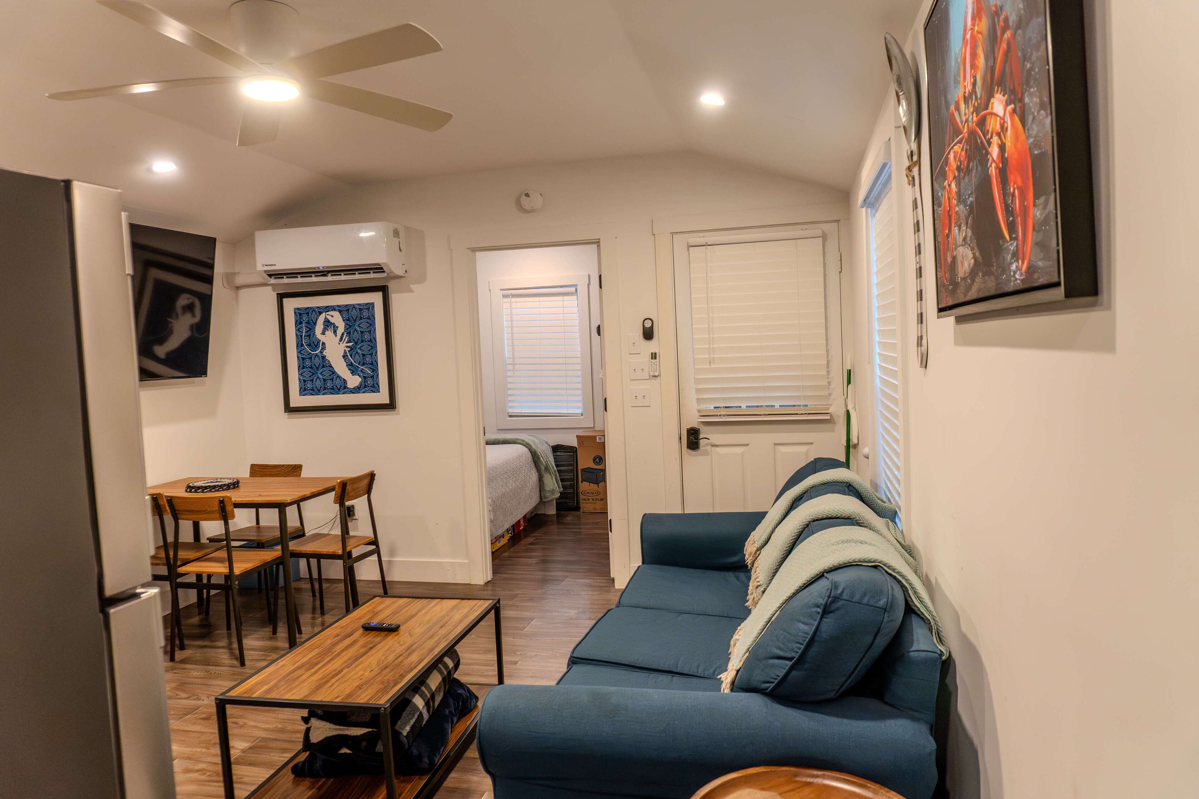 A compact living space with a dining area, a sofa, and a ceiling fan.